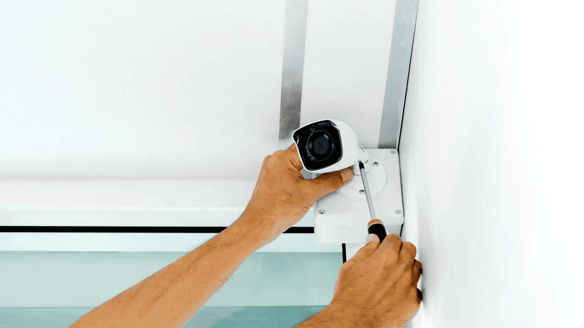 Image of a man's hands installing a CCTV camera.