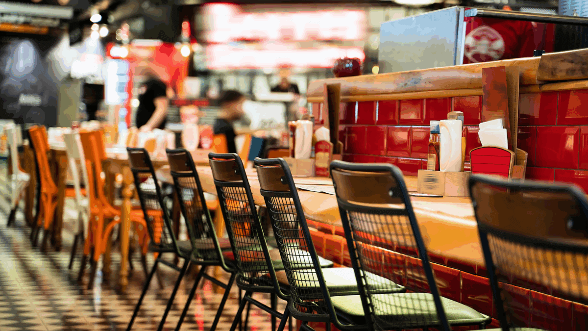 Perspective view of chairs and tables in a restaurant to illustrate QSR franchise opportunities.