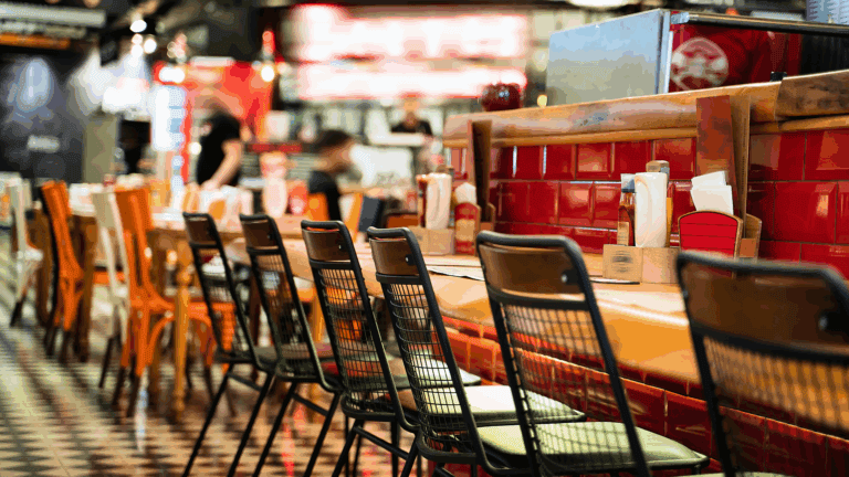 Perspective view of chairs and tables in a restaurant to illustrate QSR franchise opportunities.