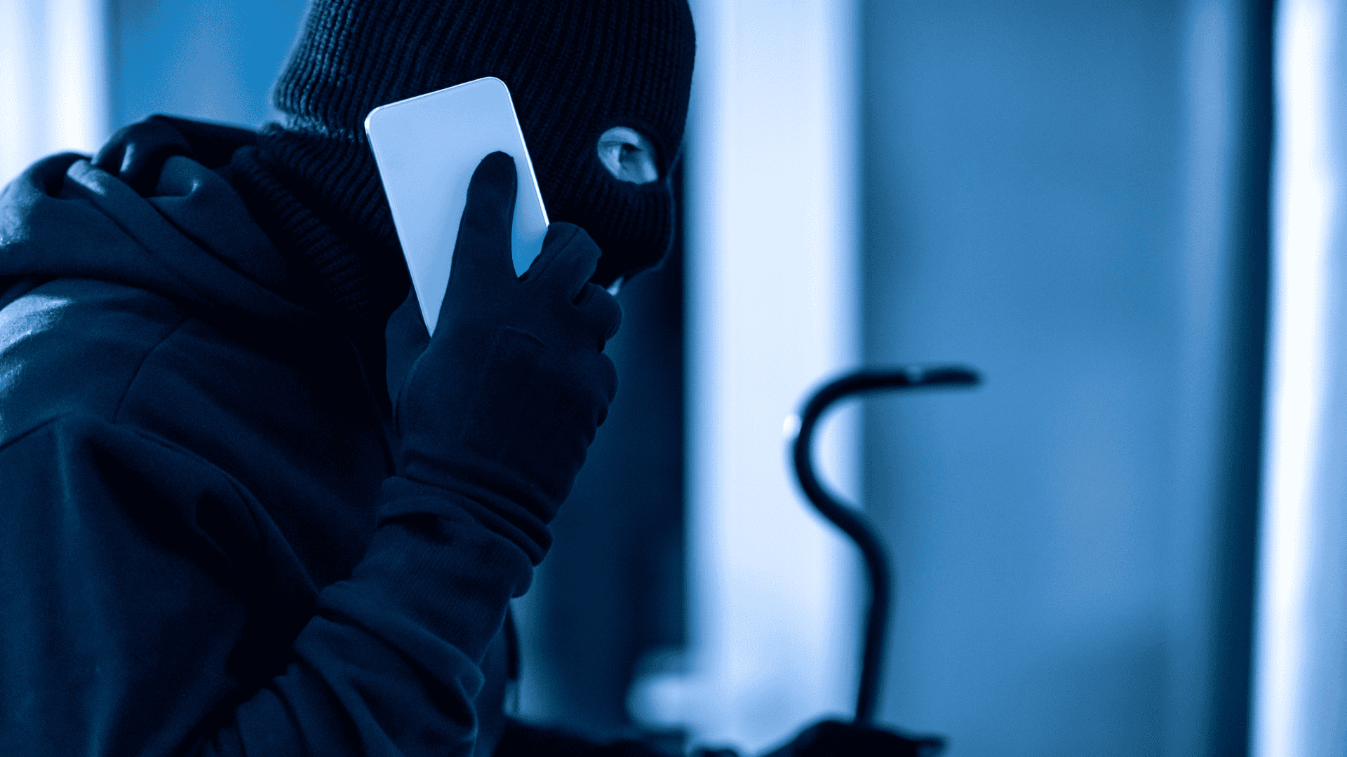 Image of a man burglar on the phone. This is a representation of intrusion detection.