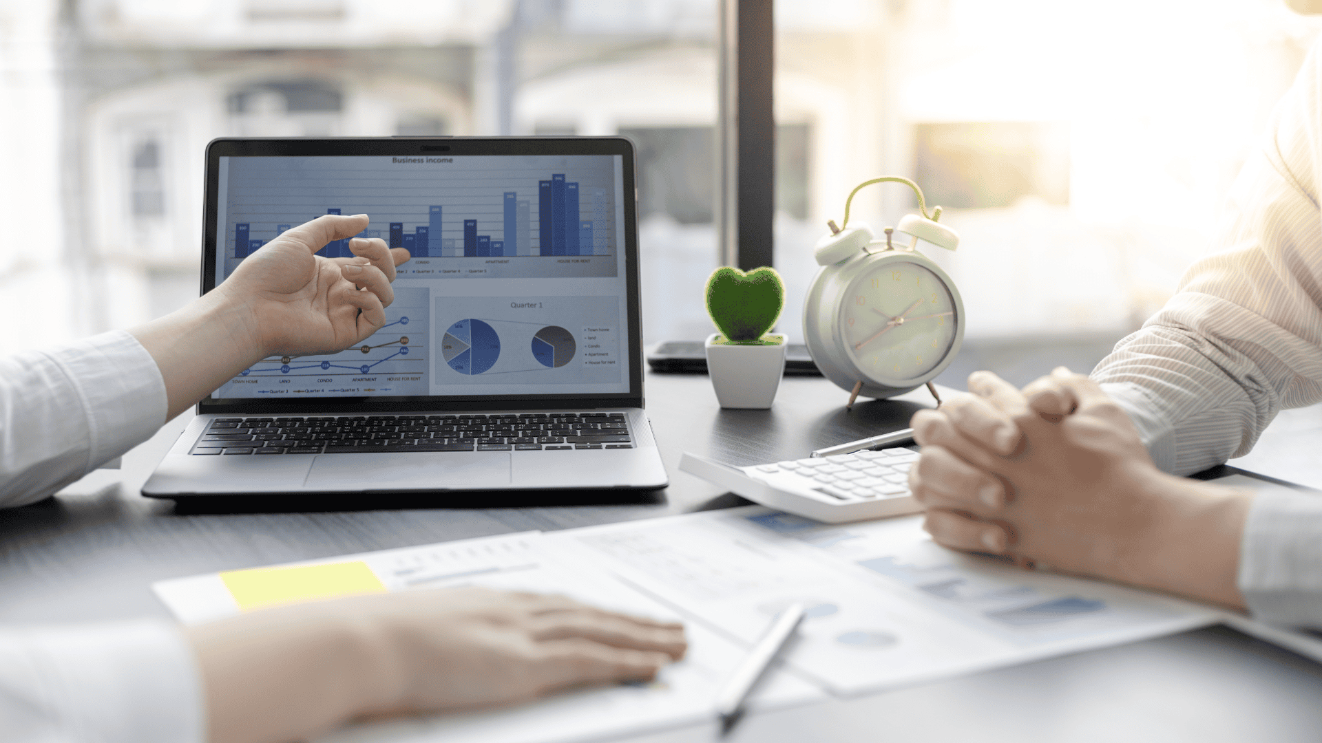 Close-up image of two people reviewing a business intelligence dashboard on a laptop.