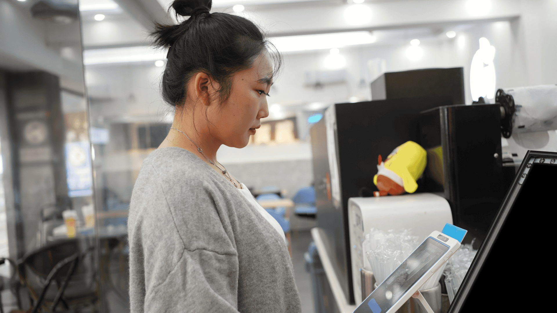 A woman standing in front of a monitor as it scans her face for facial recognition.