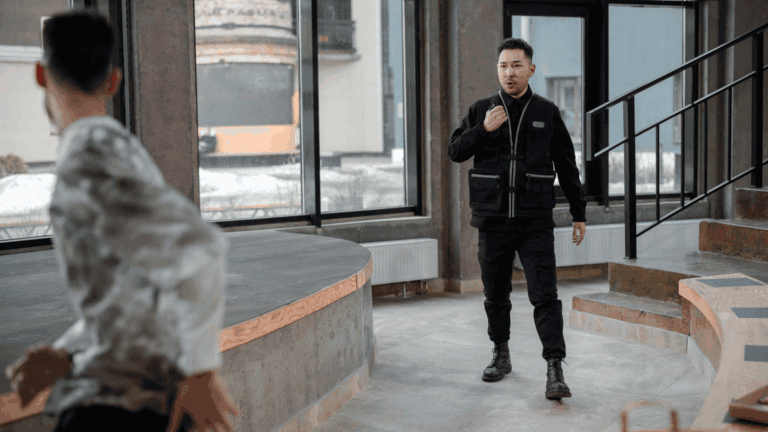 A security guard confronts a man who appears to be fleeing inside a modern office space, illustrating one of the types of employee theft.