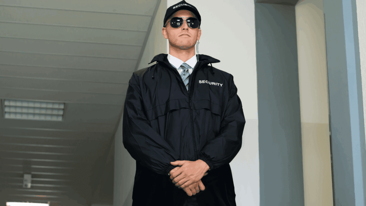 A security guard stands watchfully in a hallway, representing retail store safety guidelines that help ensure customer and staff protection.