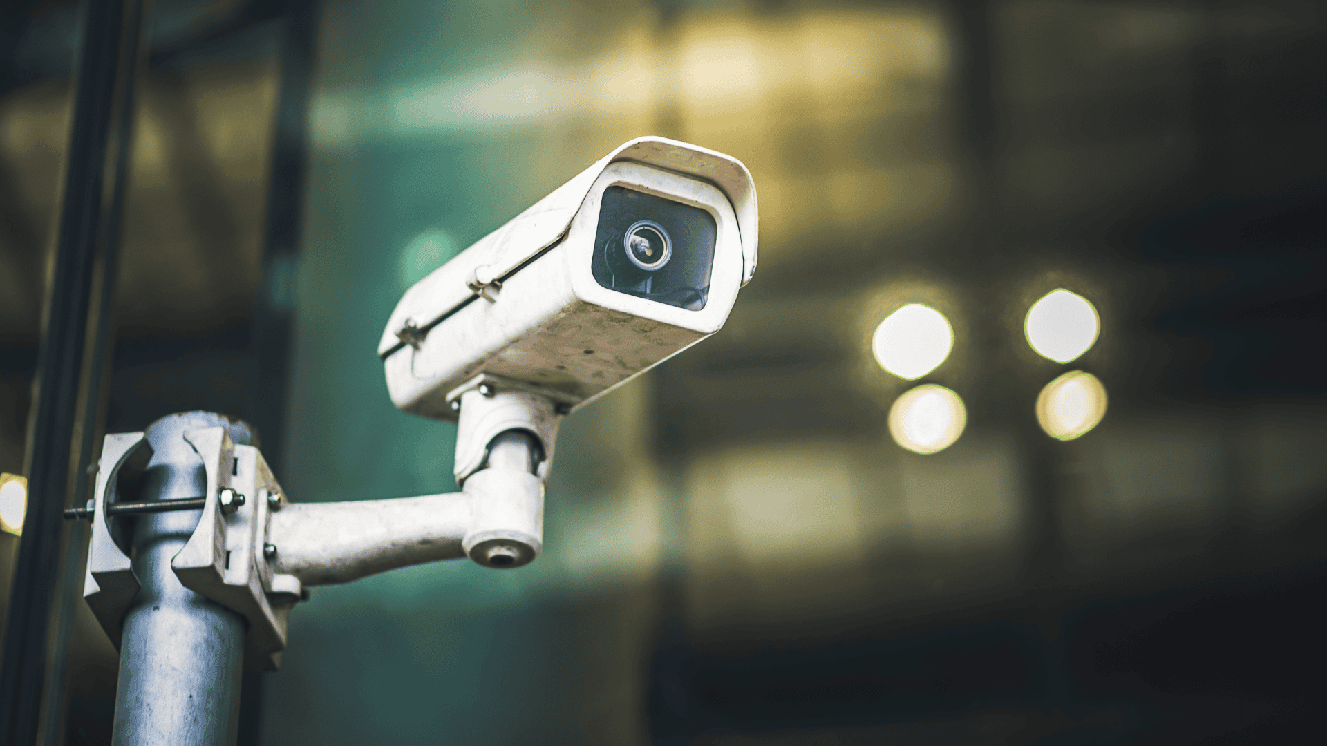 A wall-mounted security camera with a weathered exterior is aimed outward in a commercial setting, symbolizing a security camera in a store.