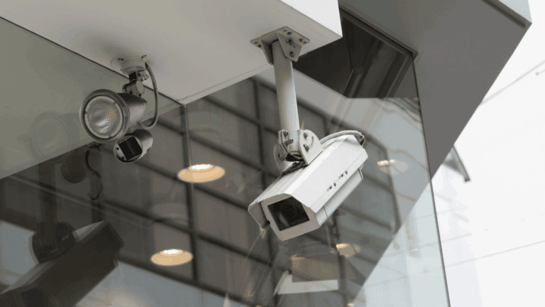 Two different types of security cameras are mounted on the exterior of a modern building, visually representing a comparison in the topic Turret vs Dome security camera.