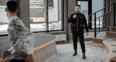 A security guard confronts a man who appears to be fleeing inside a modern office space, illustrating one of the types of employee theft.