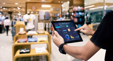A retail manager uses a tablet with sales data, illustrating average retail sales Per square foot.