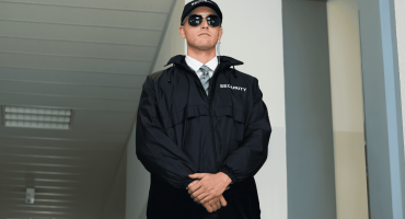A security guard stands watchfully in a hallway, representing retail store safety guidelines that help ensure customer and staff protection.